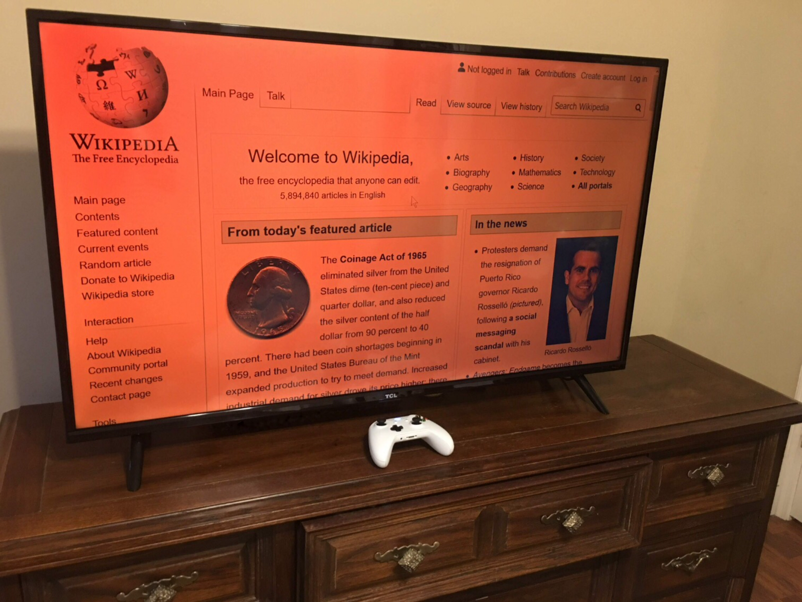 TCL TV set on stand on dresser, HDMI-connected to Windows computer, the blue light filter on, on WP homepage, with XB1 controller a remote input device Bluetooth-connected to the PC, which uses Controller Companion